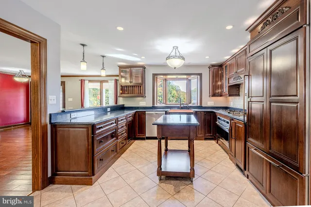 a kitchen with stainless steel appliances granite countertop a refrigerator stove top oven and sink