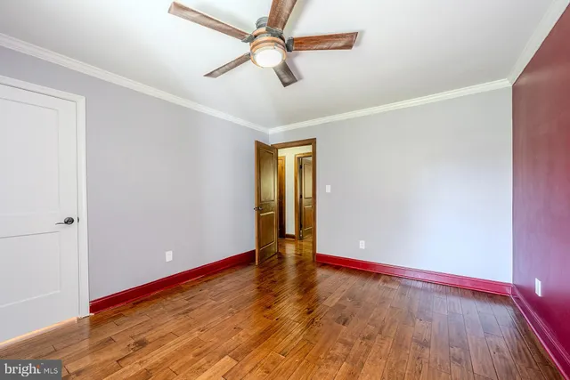 a view of empty room with wooden floor