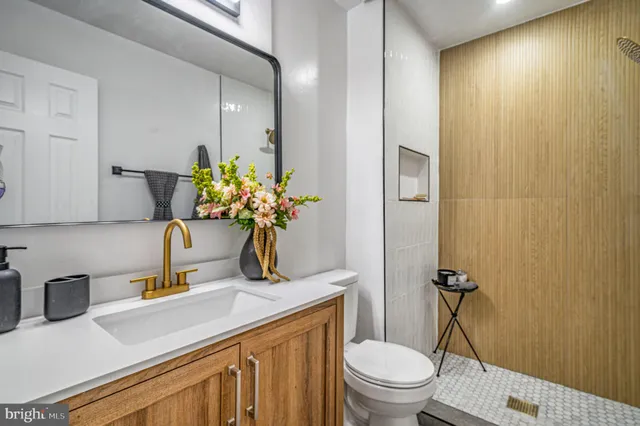 a bathroom with a granite countertop sink a toilet and mirror