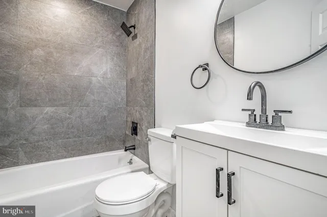 a bathroom with a toilet sink vanity tub and shower