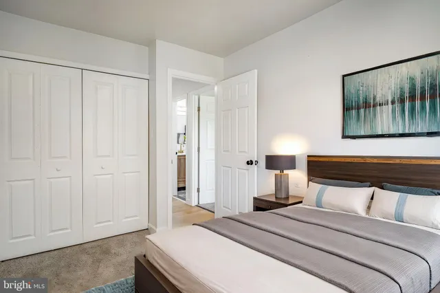 a bedroom with a bed and a painting on the wall