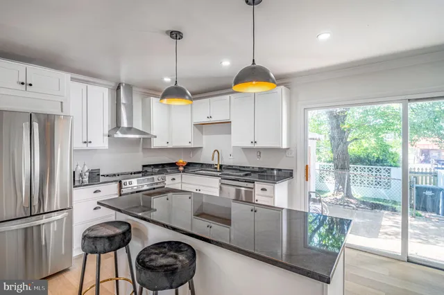 a kitchen with stainless steel appliances granite countertop a sink a stove and a refrigerator