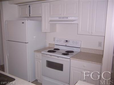 514 Raintree Street East Lehigh Acres, FL 33974 - Photo 6 of 10 a kitchen with white cabinets and white appliances