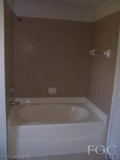 514 Raintree Street East Lehigh Acres, FL 33974 - Photo 7 of 10 a bathroom with a bathtub