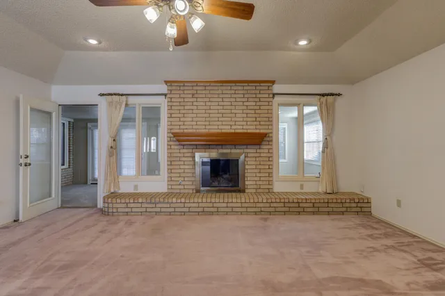 an empty room with fireplace and windows