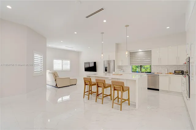 a large dining space with furniture a large window and a projector