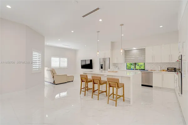 a large dining space with furniture a large window and a projector