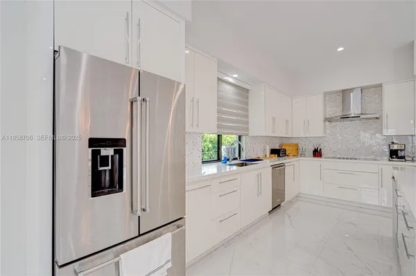 a kitchen with granite countertop white cabinets and white appliances