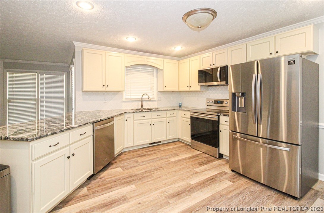 544 Blackbird Road Fayetteville, NC 28314 - Photo 13 of 36 a kitchen with white cabinets stainless steel appliances a sink and a window