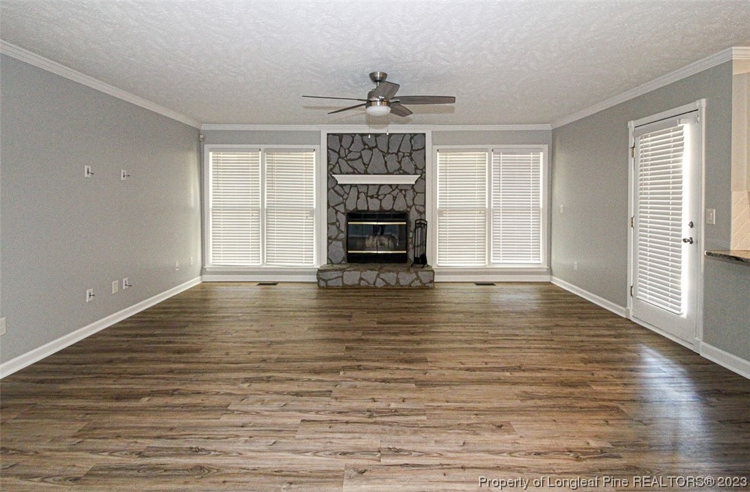 544 Blackbird Road Fayetteville, NC 28314 - Photo 7 of 36 an empty room with wooden floor fireplace and windows