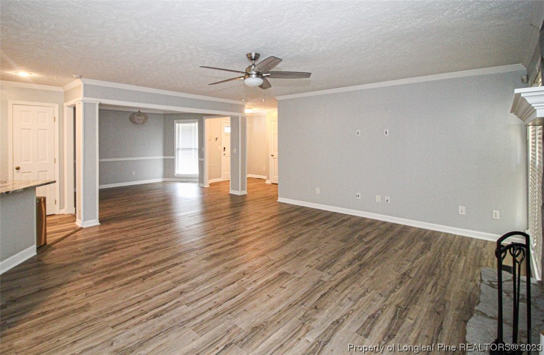 544 Blackbird Road Fayetteville, NC 28314 - Photo 9 of 36 an empty room with wooden floor chandelier fan and windows