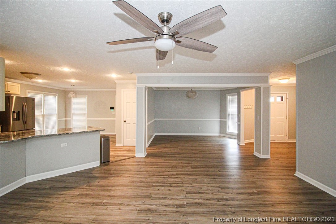 544 Blackbird Road Fayetteville, NC 28314 - Photo 10 of 36 a view of a kitchen with wooden floor and a ceiling fan