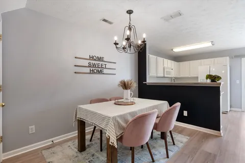 a view of a dining room with a table and chairs