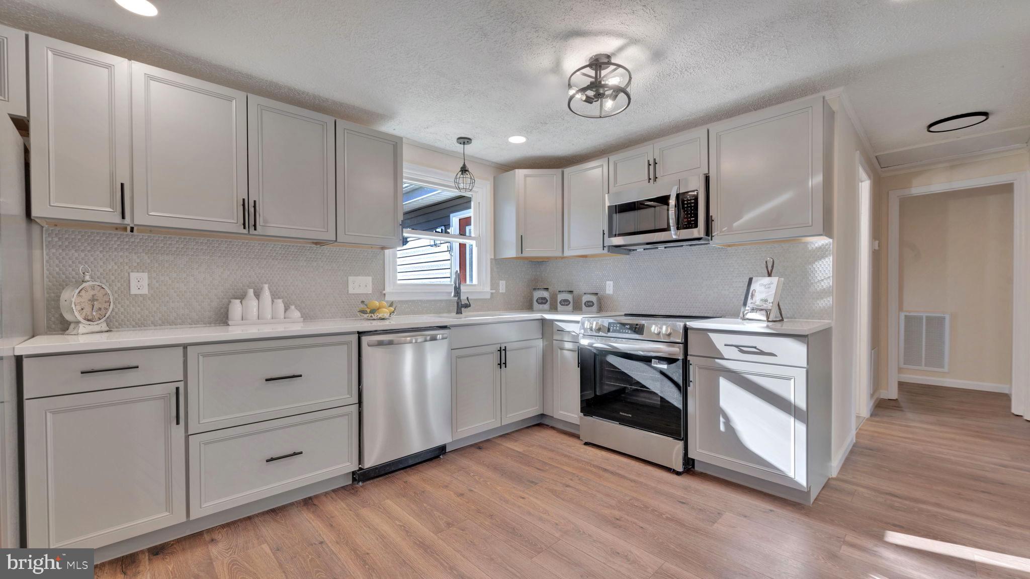 10965 La Plata Road La Plata, MD 20646 - Photo 8 of 24 a kitchen with granite countertop white cabinets stainless steel appliances and wooden floor
