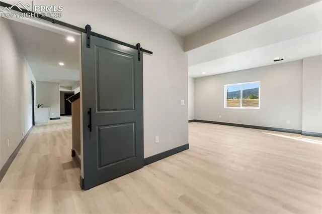 a view of empty room with a refrigerator and microwave