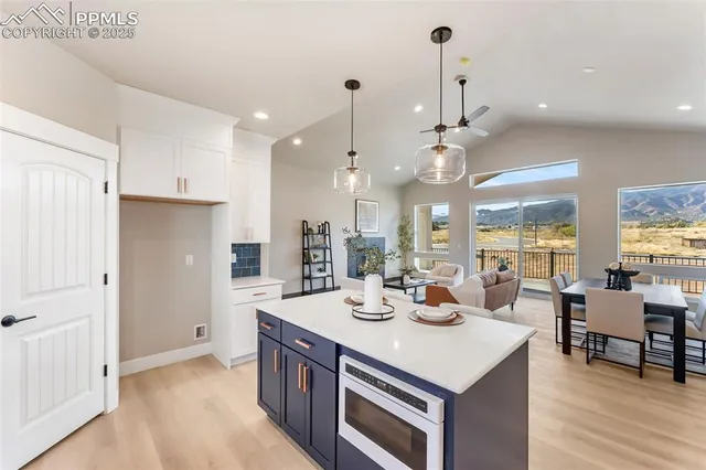 a kitchen with a sink appliances and wooden floor
