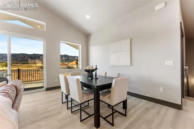 a dining room with furniture and a floor to ceiling window