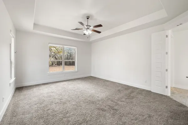 an empty room with windows and fan
