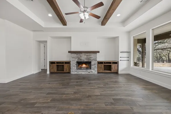 wooden floor fireplace and windows in an empty room
