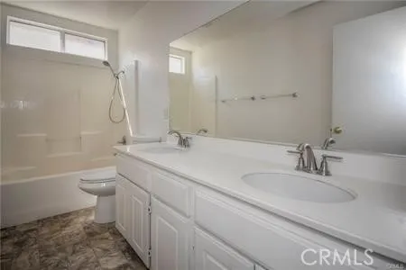 a bathroom with a granite countertop toilet a sink and a bathtub