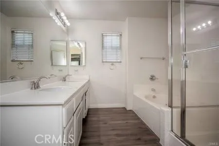 a bathroom with a double vanity sink a mirror and a bathtub