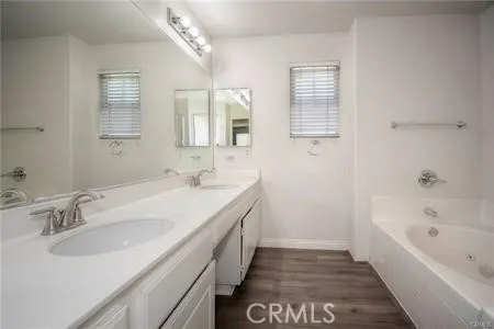 a spacious bathroom with a tub sink and mirror