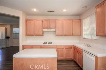 a kitchen with a sink window and cabinets
