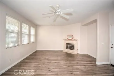a view of an empty room with window and wooden floor