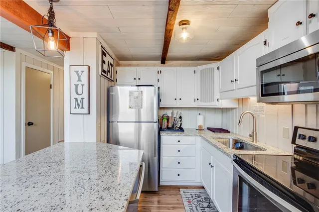 a kitchen with stainless steel appliances a refrigerator sink and cabinets