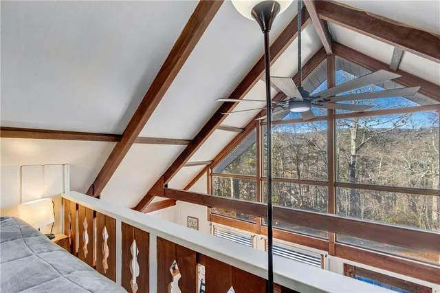 a view of a hallway with bathroom and wooden floor