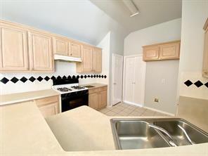 3169 Riverside Drive Carrollton, TX 75007 - Photo 5 of 16 a kitchen with granite countertop a sink and white cabinets