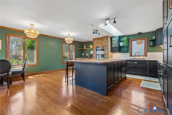 a dining room with furniture a chandelier and wooden floor