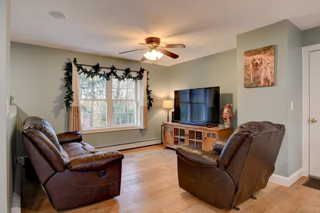 a living room with furniture a ceiling fan and a window