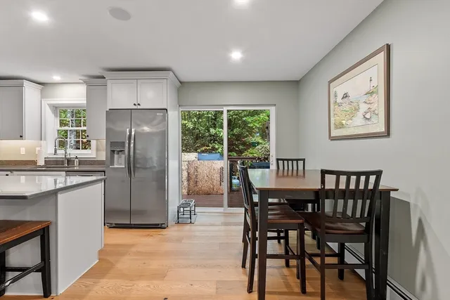 a kitchen with stainless steel appliances a dining table chairs and refrigerator