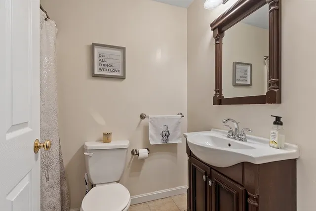 a bathroom with a toilet a sink and mirror