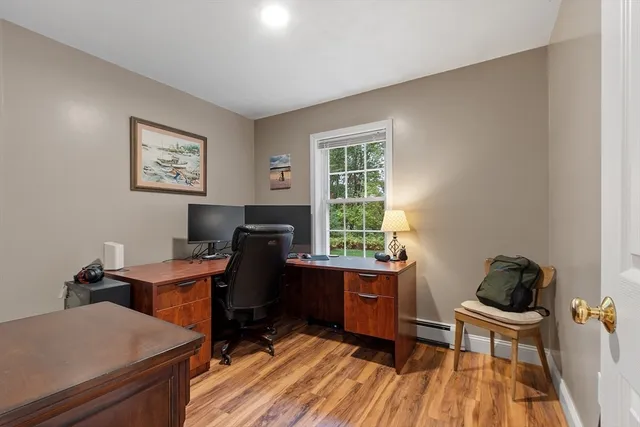 a view of a workspace with furniture and a window