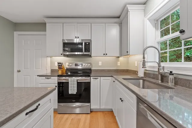 a kitchen with stainless steel appliances granite countertop a sink stove and microwave