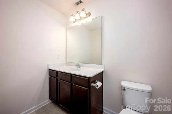 a bathroom with a sink a toilet a mirror and vanity
