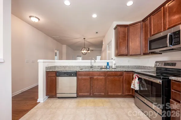a kitchen with stainless steel appliances granite countertop a stove a sink and a microwave