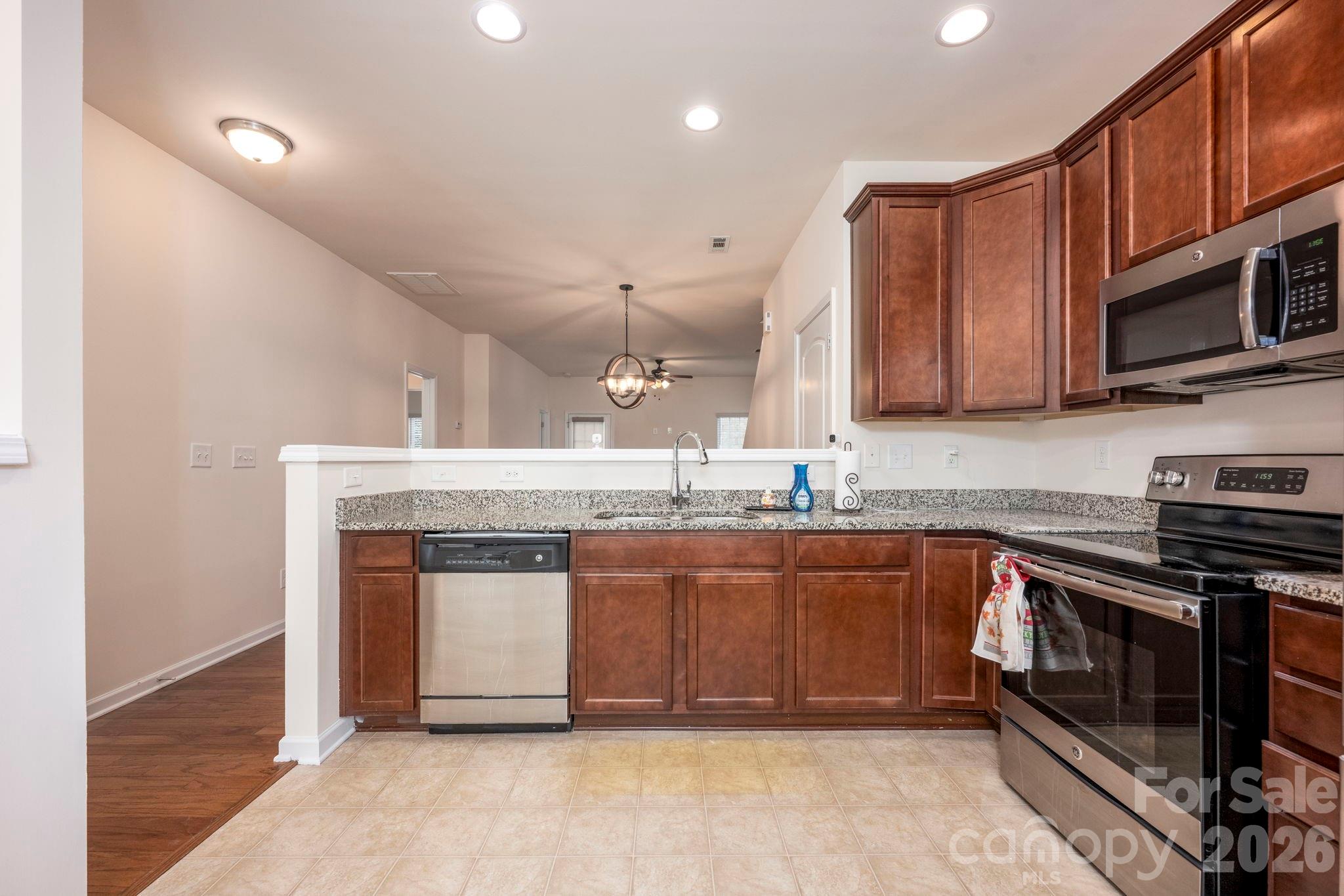 179 Limerick Road, Unit D Mooresville, NC 28115 - Photo 8 of 21 a kitchen with stainless steel appliances granite countertop a stove a sink and a microwave