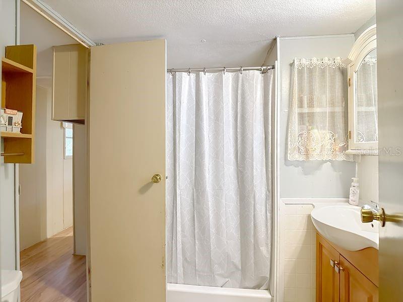 8145 Campbell Court New Port Richey, FL 34653 - Photo 18 of 34 a bathroom with a shower curtain and a sink
