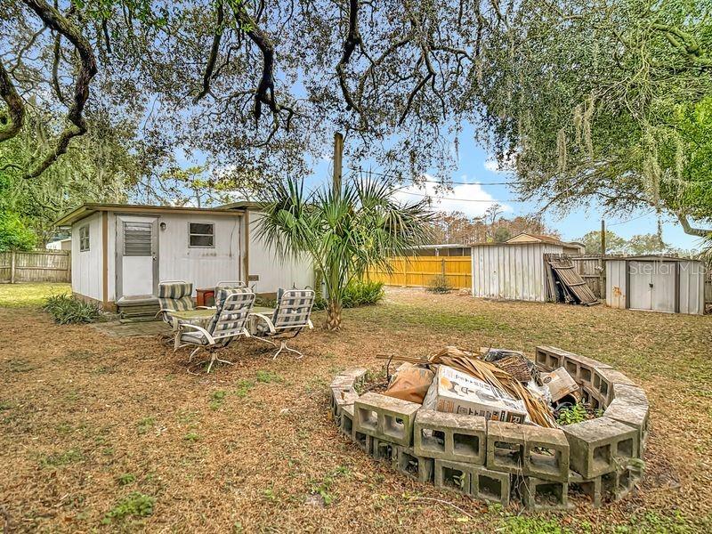 8145 Campbell Court New Port Richey, FL 34653 - Photo 24 of 34 a view of a patio with table and chairs and potted plants with large tree