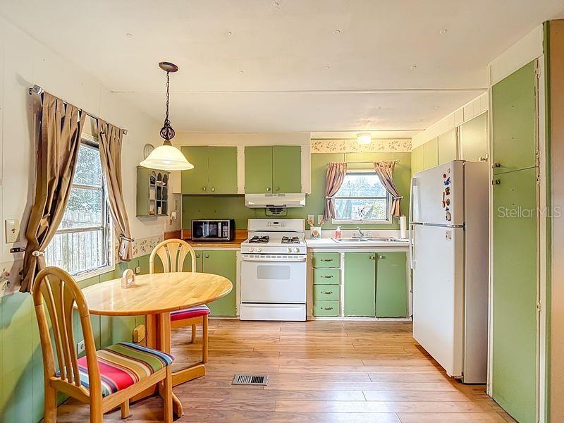 8145 Campbell Court New Port Richey, FL 34653 - Photo 5 of 34 a kitchen with sink cabinets and wooden floor