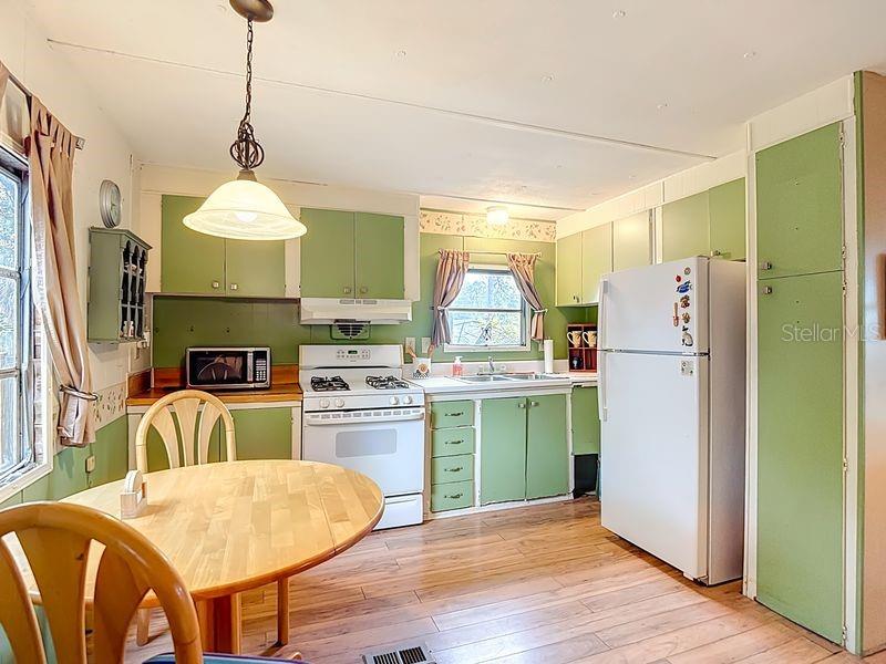 8145 Campbell Court New Port Richey, FL 34653 - Photo 7 of 34 a kitchen with sink refrigerator and cabinets