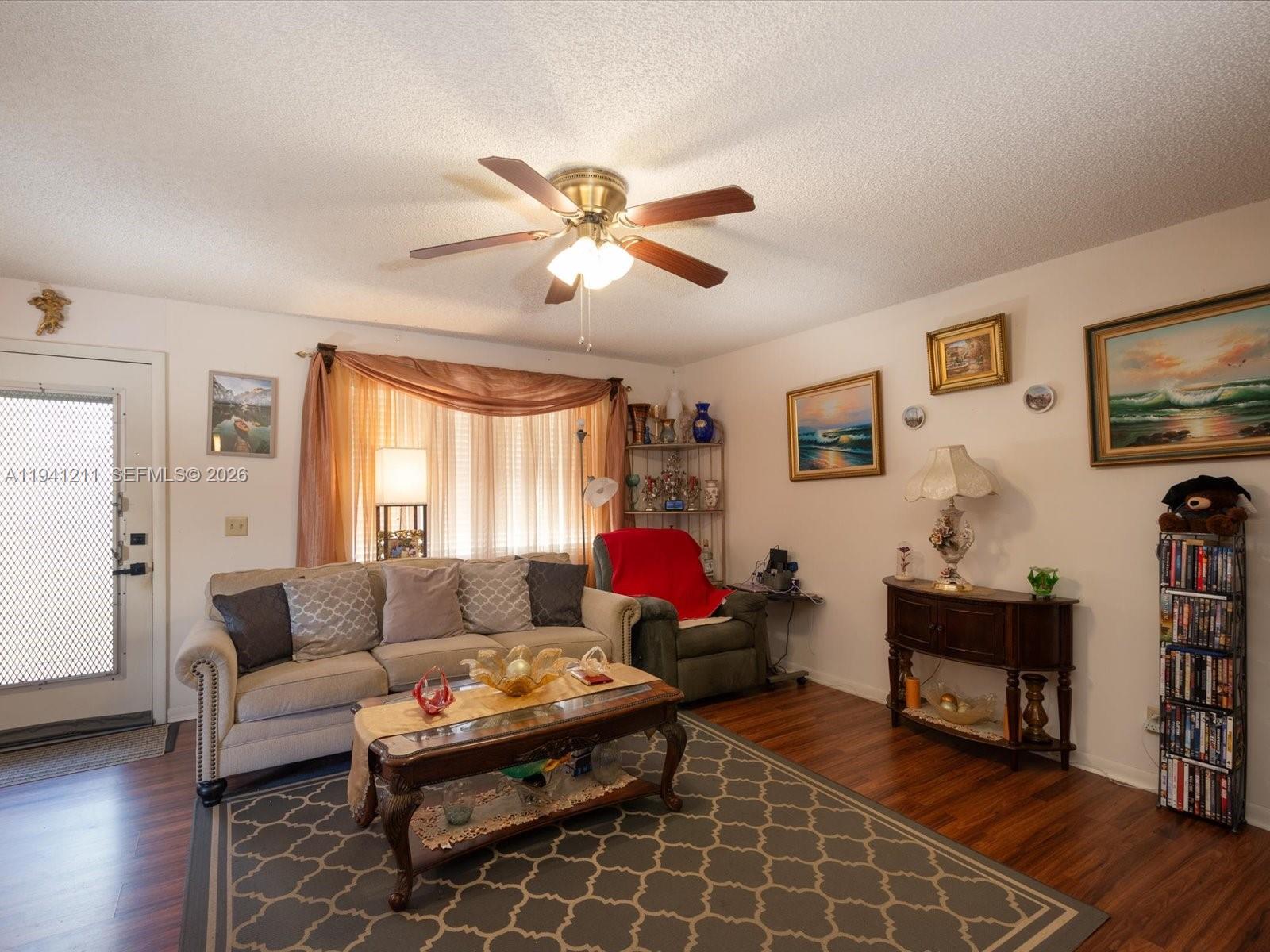 414 Capri H, Unit 414 Delray Beach, FL 33484 - Photo 11 of 19 a living room with furniture a flat screen tv and a window