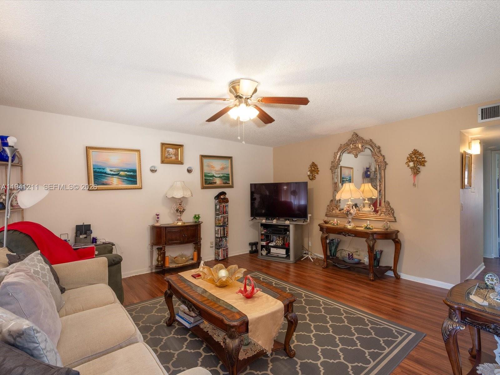 414 Capri H, Unit 414 Delray Beach, FL 33484 - Photo 13 of 19 a living room with furniture a flat screen tv and a fireplace