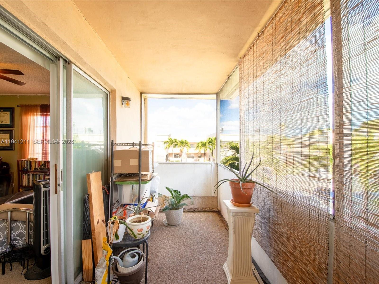 414 Capri H, Unit 414 Delray Beach, FL 33484 - Photo 16 of 19 a view of a living room with furniture and a floor to ceiling window