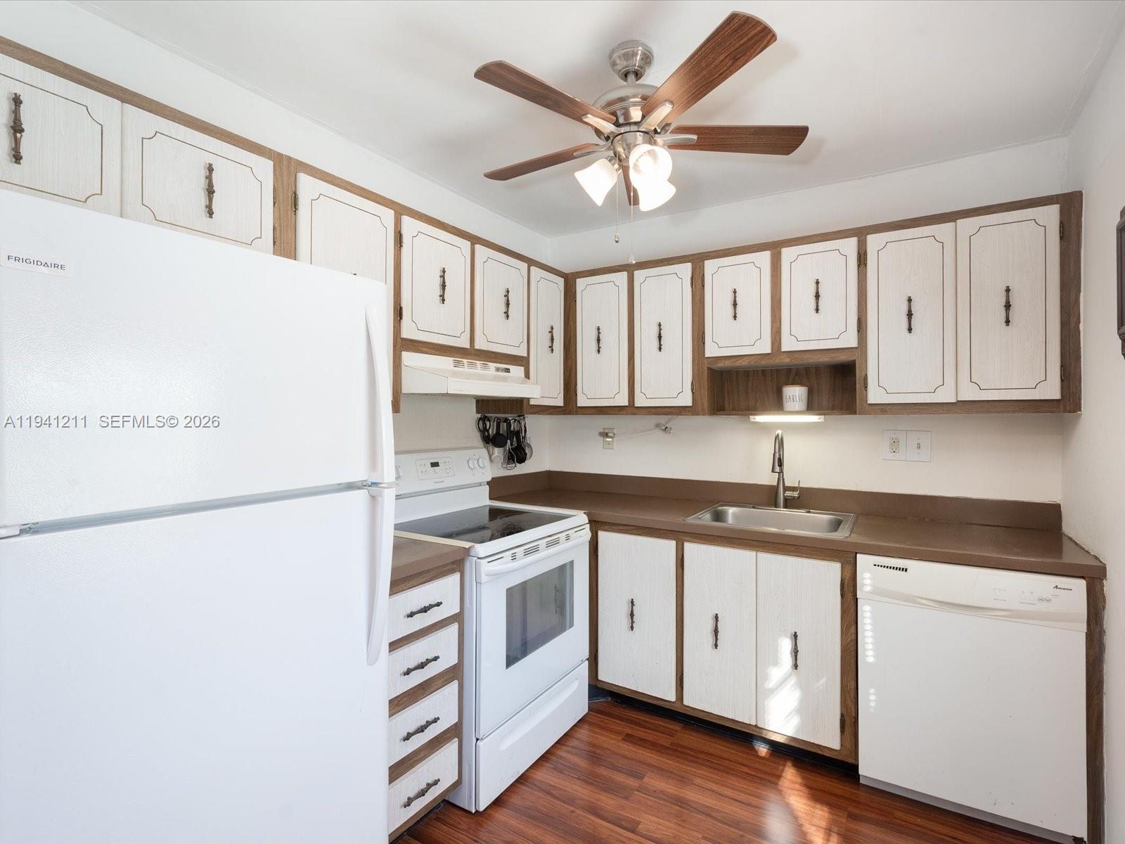 414 Capri H, Unit 414 Delray Beach, FL 33484 - Photo 3 of 19 a kitchen with granite countertop white cabinets white stainless steel appliances and sink