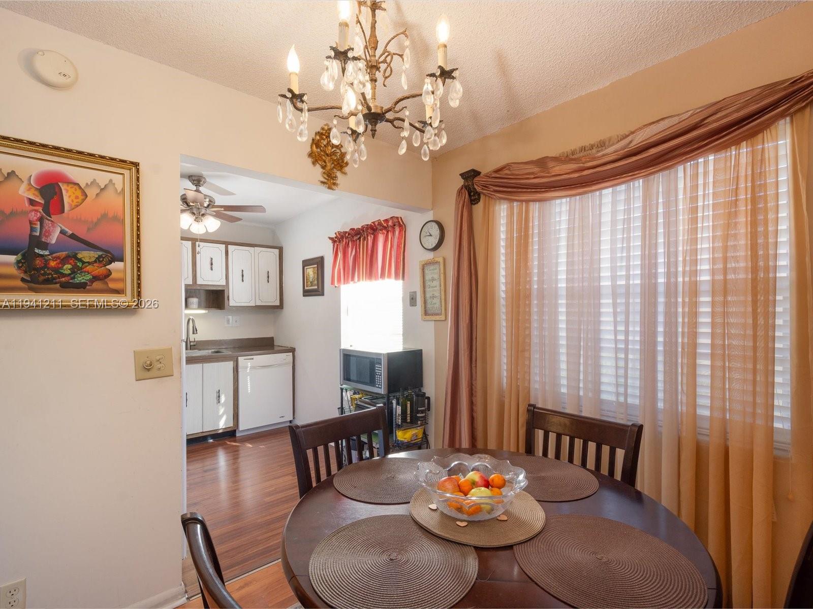 414 Capri H, Unit 414 Delray Beach, FL 33484 - Photo 5 of 19 a view of a dining room with furniture a chandelier and wooden floor