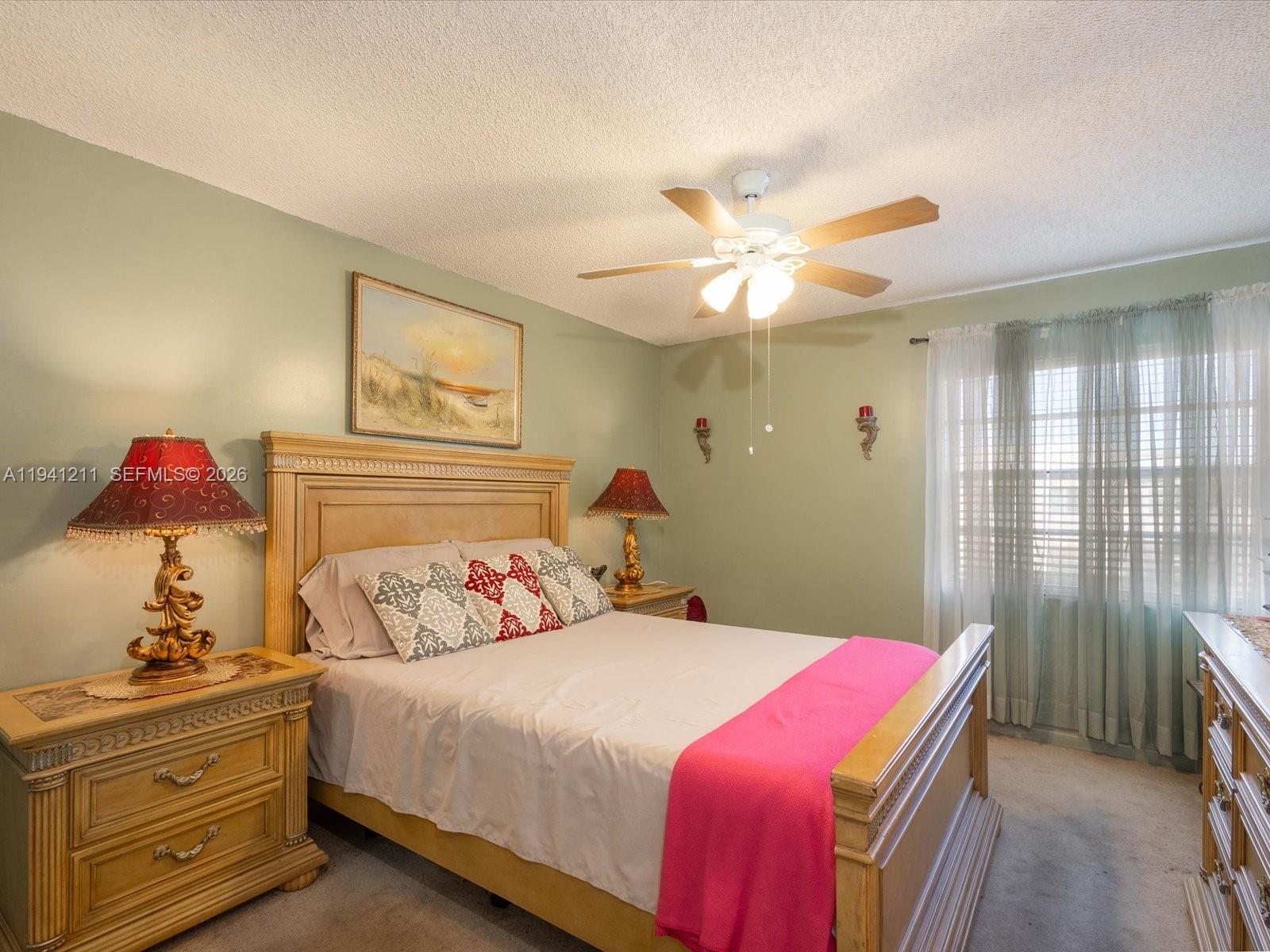 414 Capri H, Unit 414 Delray Beach, FL 33484 - Photo 7 of 19 a bedroom with a bed and a chandelier